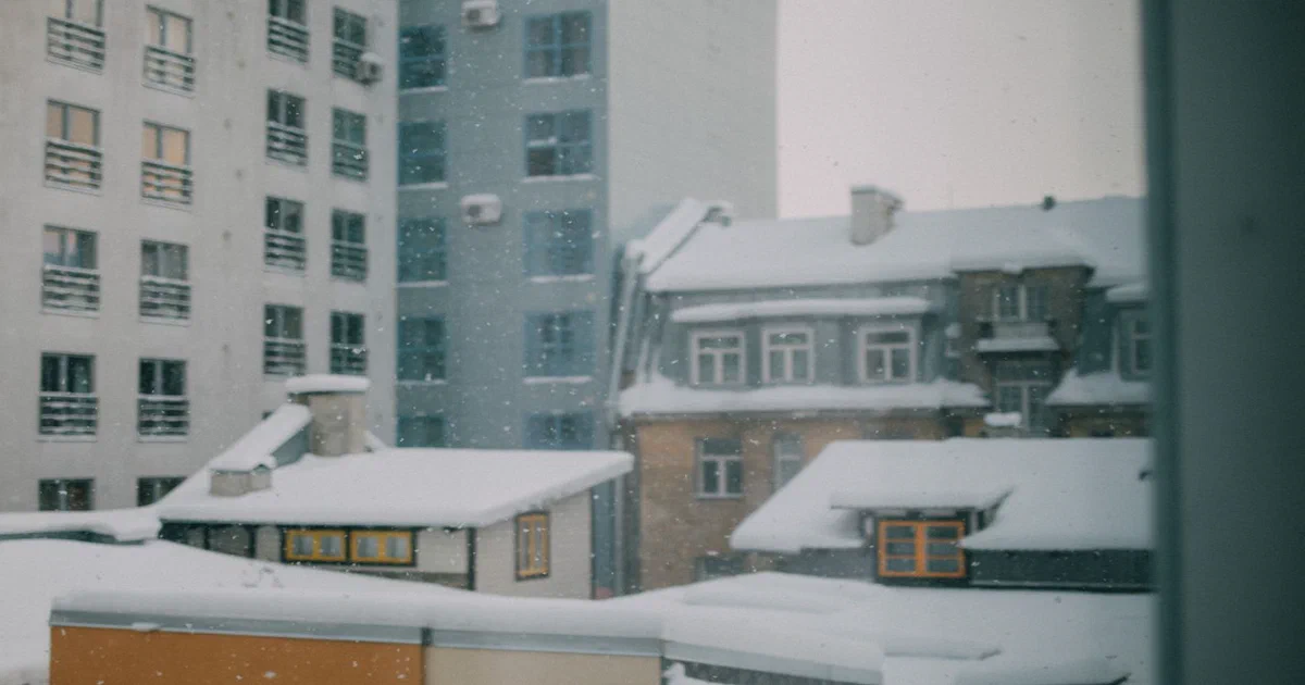 Toits enneigés d'immeubles en ville pendant une chute de neige